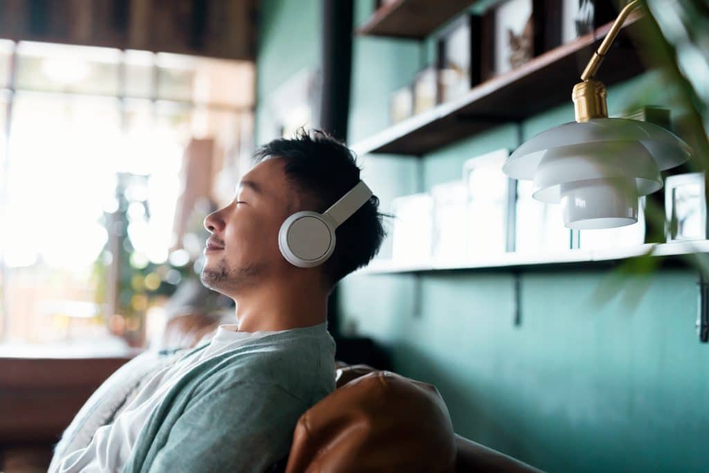 Person listening on headphones with eyes closed