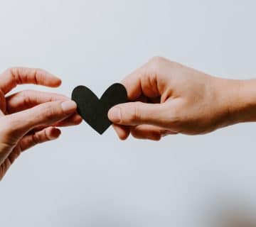 two person holding papercut heart