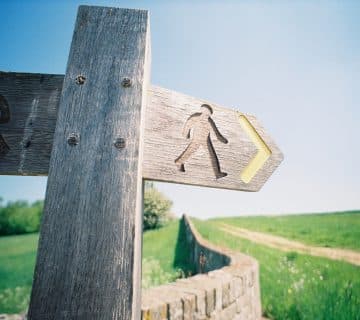 brown wooden cross with arrow sign