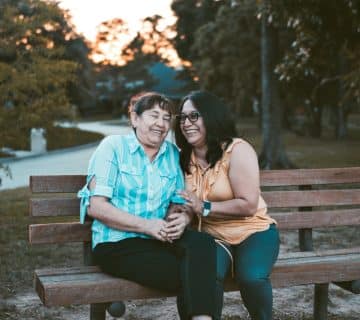 Two women sitting on a bench.